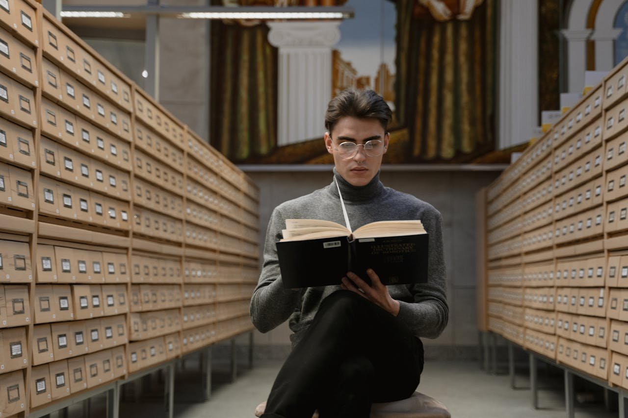 Man in Black Jacket Holding Black Book